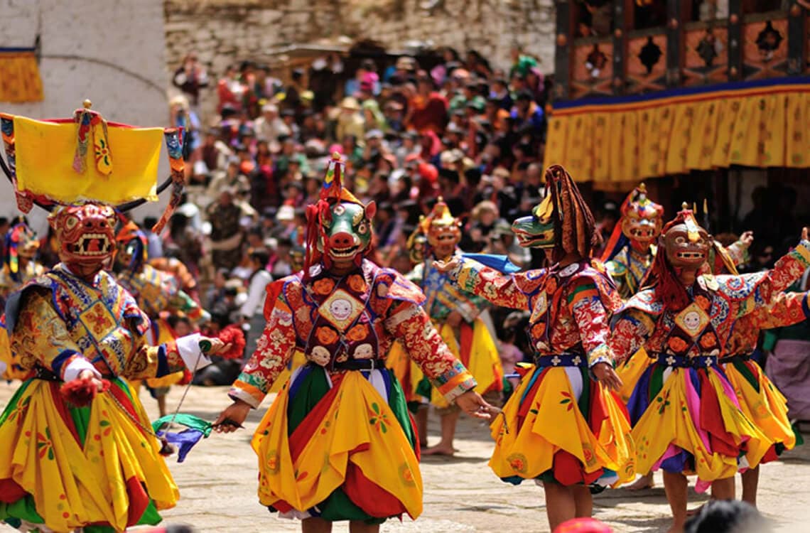 Monks in traditional attire performing sacred masked dances during the Tiji Festival Trek in the walled city of Lo Manthang, Upper Mustang.