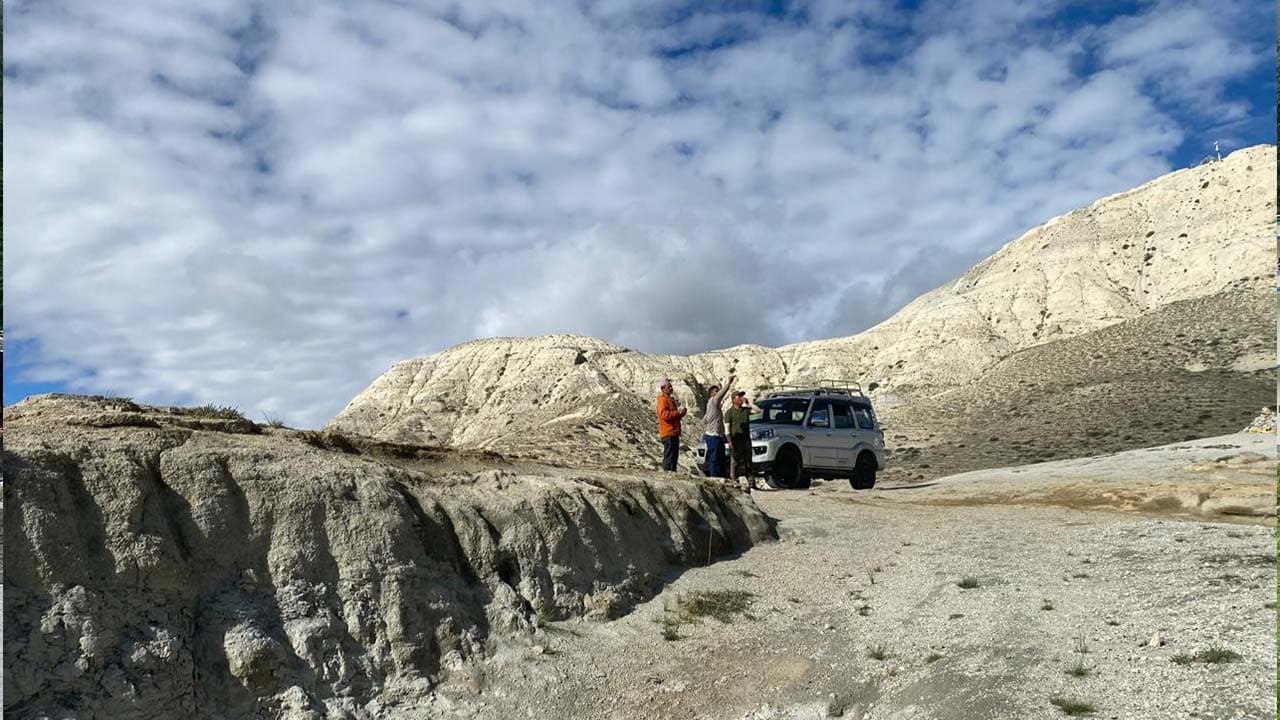 Tourists and off-road jeep stopping by barren mountain landscapes on the Upper Mustang Jeep Tour.