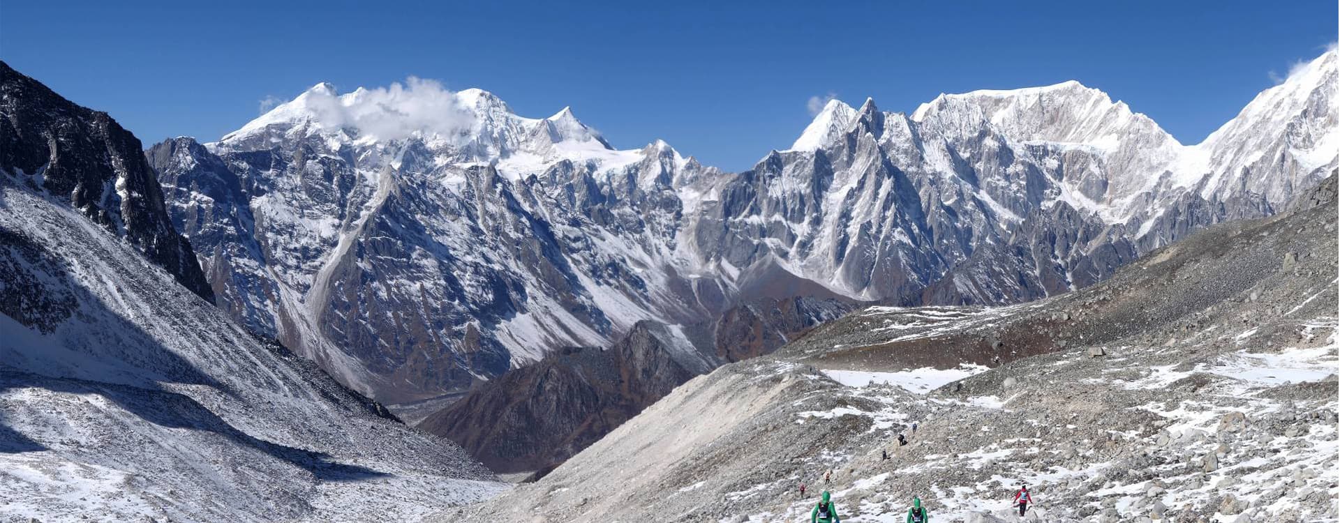 Panoramic view of high, snow-covered Himalayan peaks in the Manaslu region under a clear blue sky.