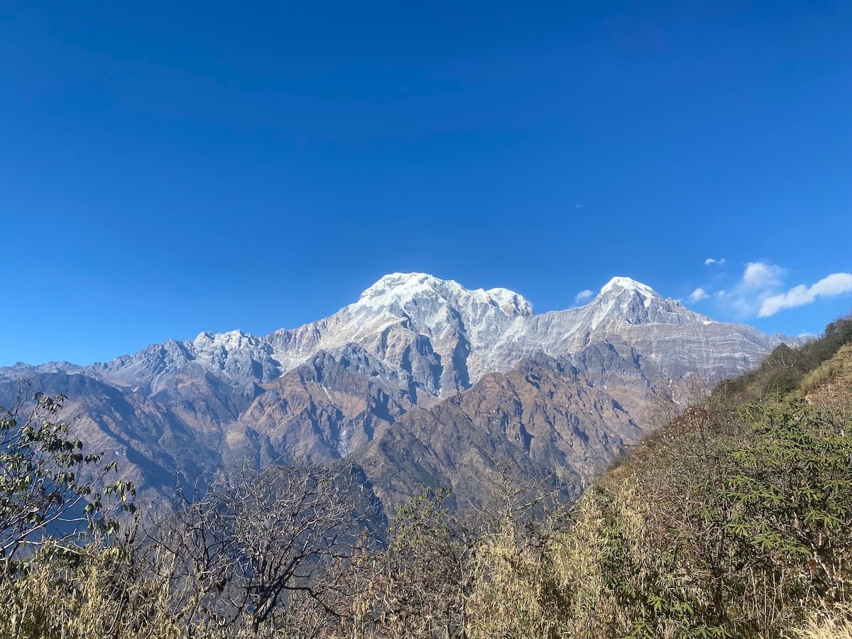 Snow-covered peaks of Annapurna South and Hiunchuli towering over deep mountain valleys in the Annapurna Sanctuary region.