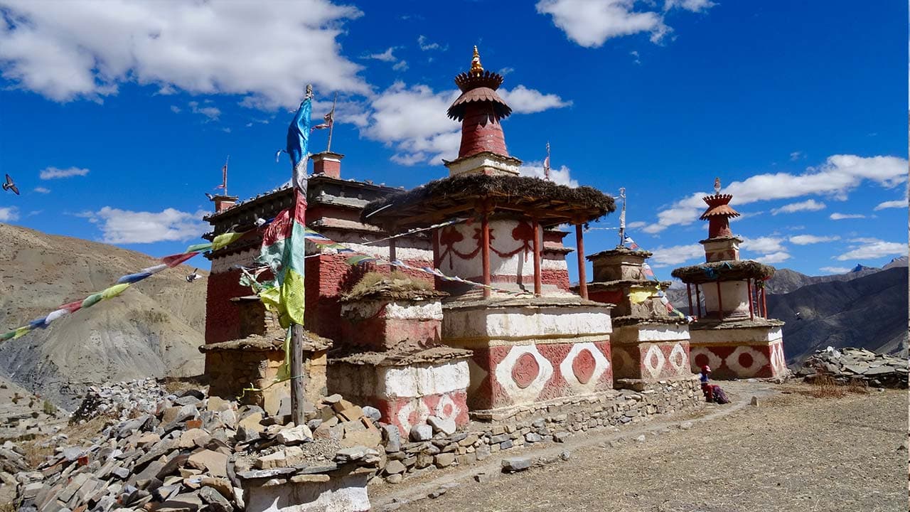 Traditional Tibetan Buddhist gompa and whitewashed chortens with prayer flags on the Upper Dolpo Trek.