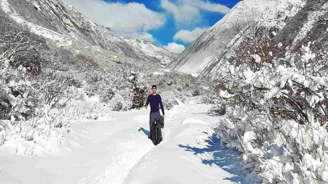 Trekker on a snowy alpine trail surrounded by dramatic winter mountains during the 20 days Manaslu Circuit with Tsum Valley Trek.