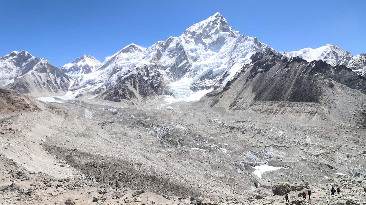 Wide aerial view of the rocky Khumbu Glacier and icy moraine surrounded by high snow-capped Himalayan peaks in Nepal.