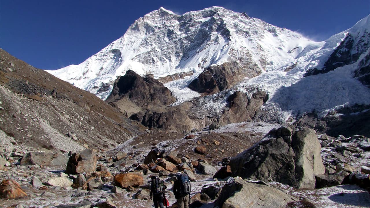 Trekkers in front of snowy Himalayan mountains on the Makalu Base Camp Trek.